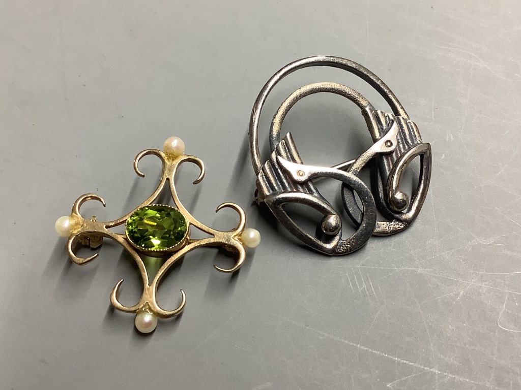 A modern 9ct gold, peridot and seed pearl set brooch, 27mm, gross 2.4 grams and a white metal brooch.